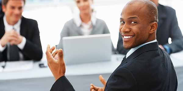  A man in formal attire seated at a table with companions.